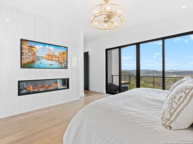 bedroom with light hardwood / wood-style floors and a notable chandelier