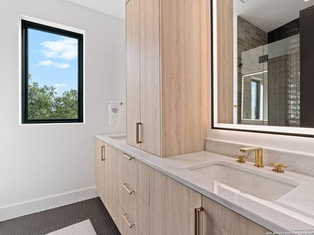 bathroom featuring a shower with shower door, vanity, and tile patterned flooring