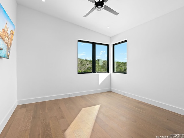 unfurnished room with light wood-type flooring, ceiling fan, lofted ceiling, and baseboards