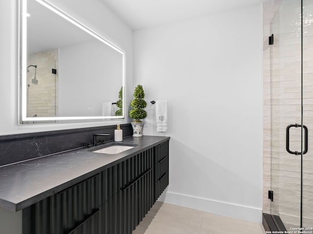 full bathroom with a stall shower, vanity, and baseboards