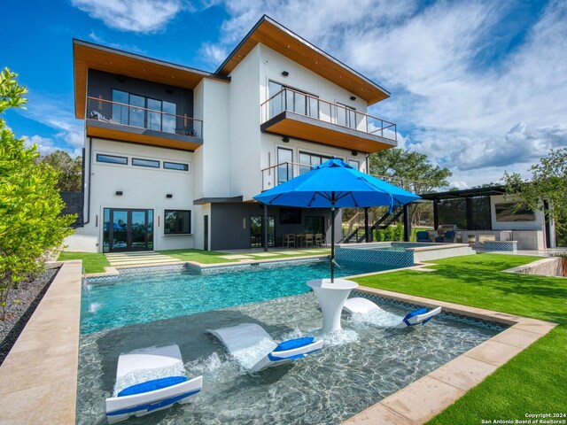 view of swimming pool featuring pool water feature, a yard, and a patio area