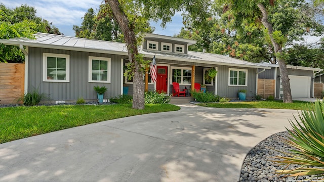 view of front facade featuring covered porch, a garage, and a front lawn