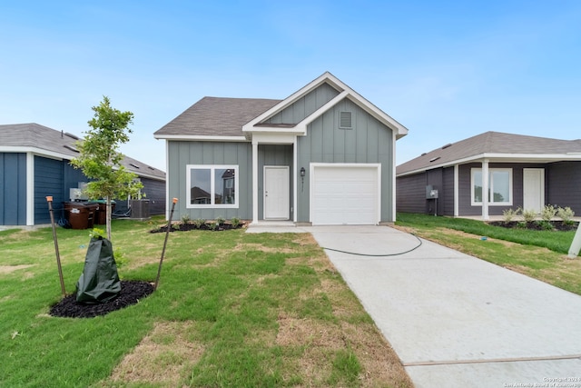 view of front facade with cooling unit, a garage, and a front lawn