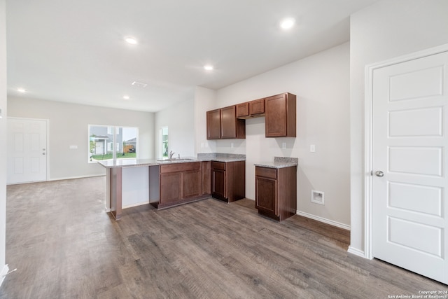 kitchen with hardwood / wood-style floors, sink, and kitchen peninsula