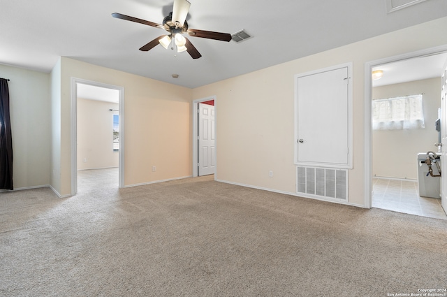 empty room featuring light colored carpet and ceiling fan