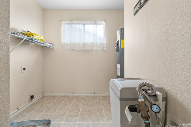 clothes washing area featuring light tile patterned flooring, electric water heater, and hookup for an electric dryer