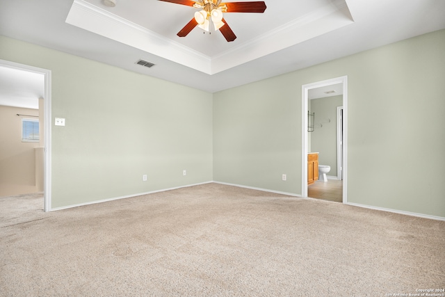 carpeted empty room featuring ceiling fan, crown molding, and a tray ceiling