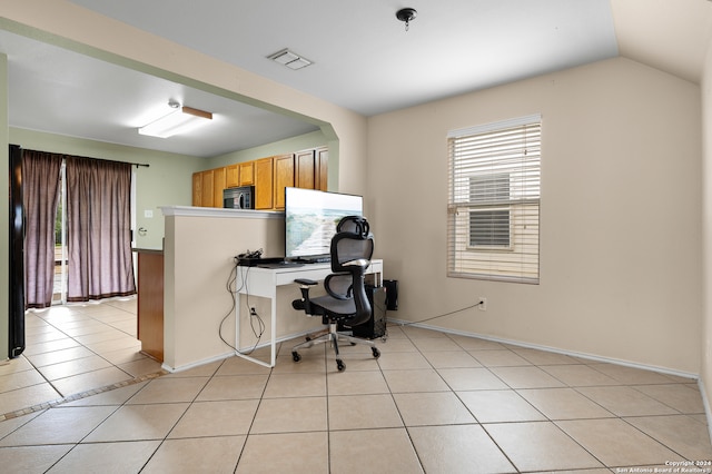 office space with light tile patterned floors and vaulted ceiling