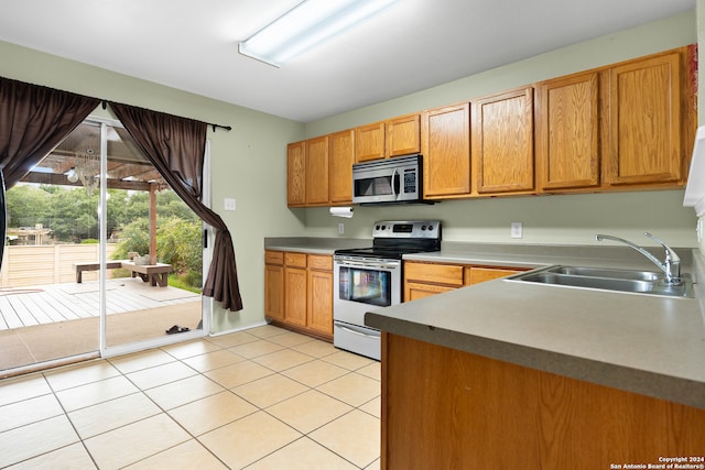 kitchen featuring sink, light tile patterned floors, and electric range oven