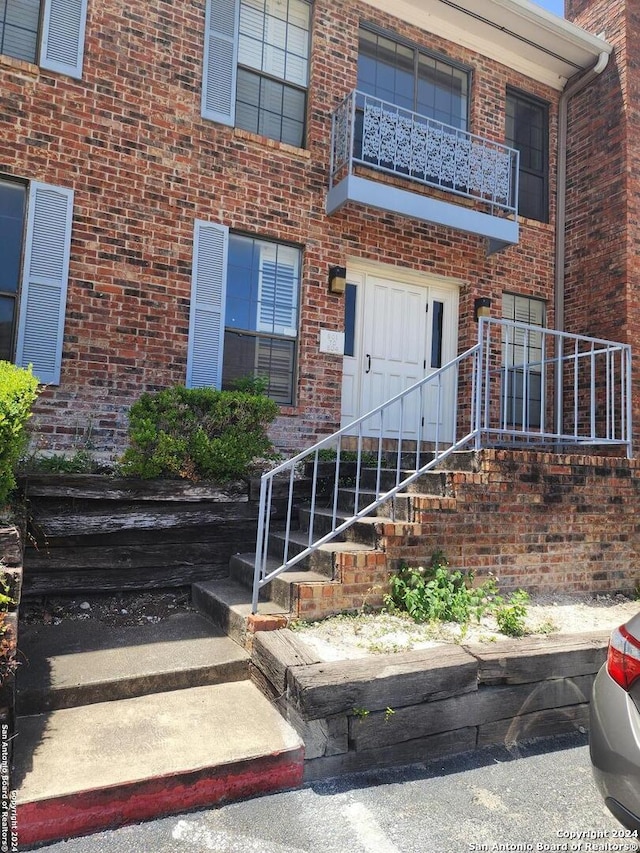 view of exterior entry featuring a balcony