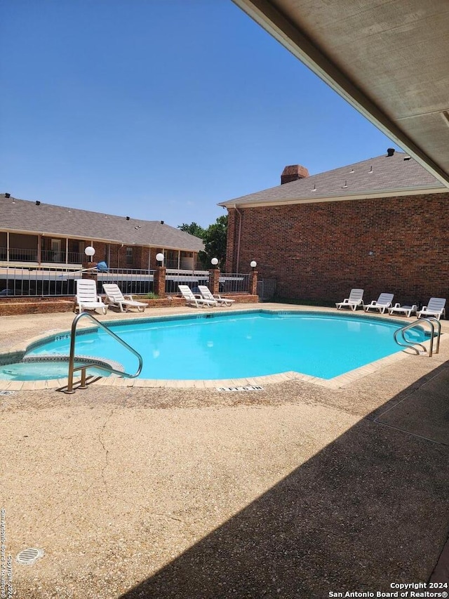 view of pool featuring a hot tub and a patio area