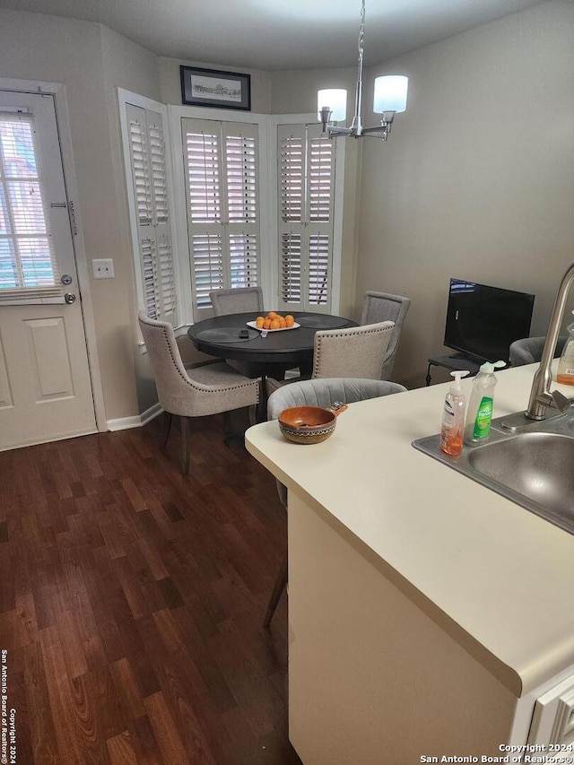 dining space featuring sink, a chandelier, and hardwood / wood-style floors