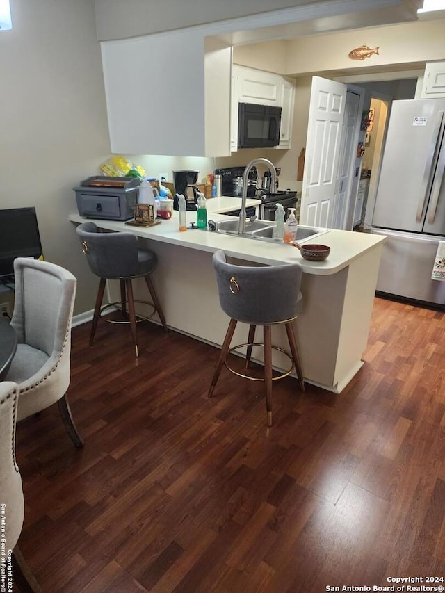 kitchen with hardwood / wood-style floors, white cabinetry, and stainless steel fridge