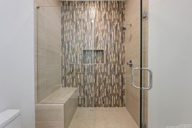 bathroom featuring toilet and an enclosed shower