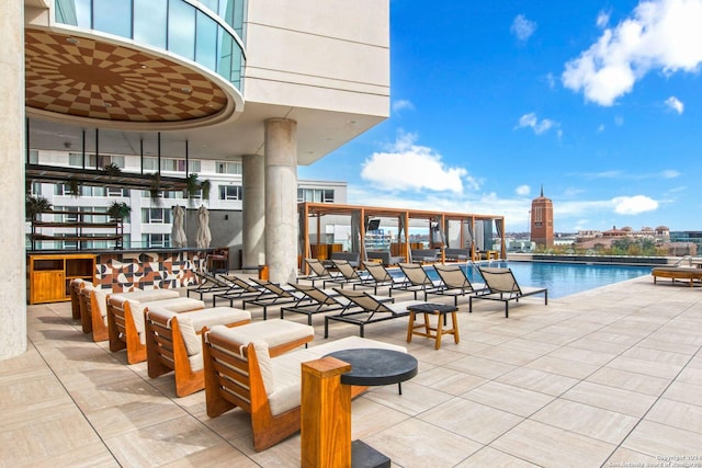 view of patio with a balcony and a community pool