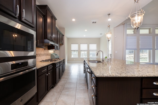 kitchen with sink, plenty of natural light, pendant lighting, and backsplash