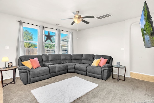 carpeted living room with ceiling fan