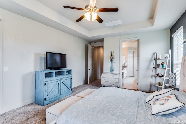 carpeted bedroom featuring a tray ceiling and ceiling fan