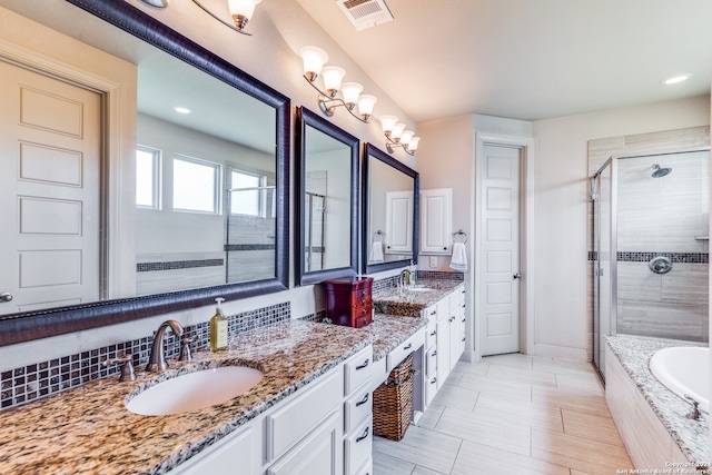 bathroom featuring tile patterned flooring, backsplash, dual vanity, and separate shower and tub