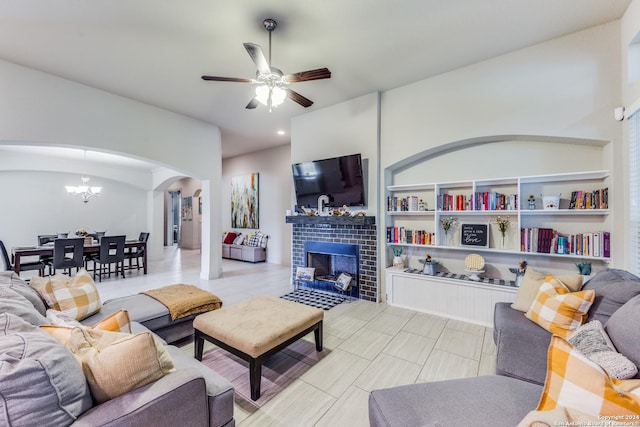 3218 Lilly Flower, San Antonio, TX 78253 - living area featuring arched walkways, ceiling fan, a tile fireplace, and a chandelier