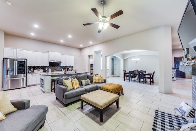 living room featuring ceiling fan with notable chandelier and light tile patterned floors