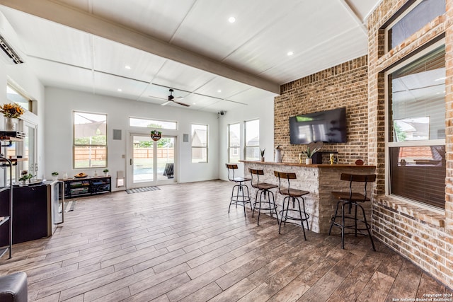 interior space with brick wall, a wall mounted air conditioner, wood-type flooring, and ceiling fan