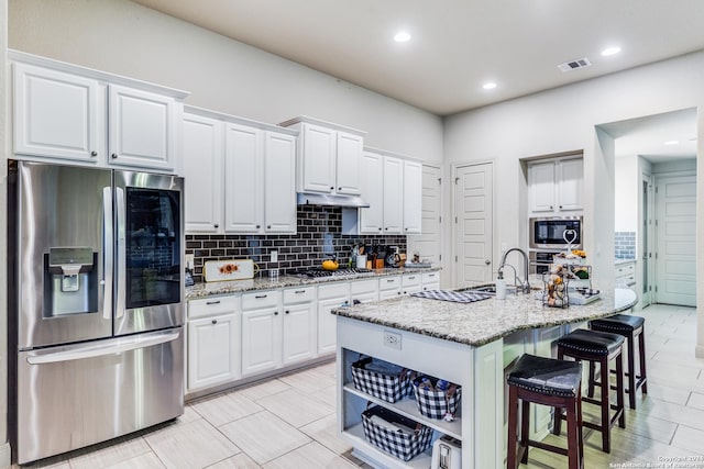 3218 Lilly Flower, San Antonio, TX 78253 - kitchen with appliances with stainless steel finishes, decorative backsplash, a kitchen breakfast bar, white cabinets, and recessed lighting