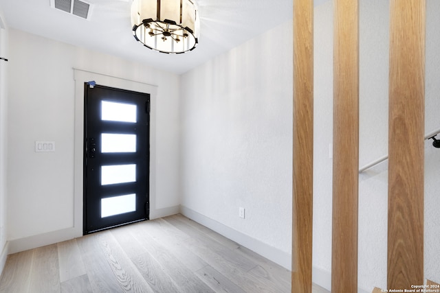 entryway featuring a chandelier and light wood-type flooring