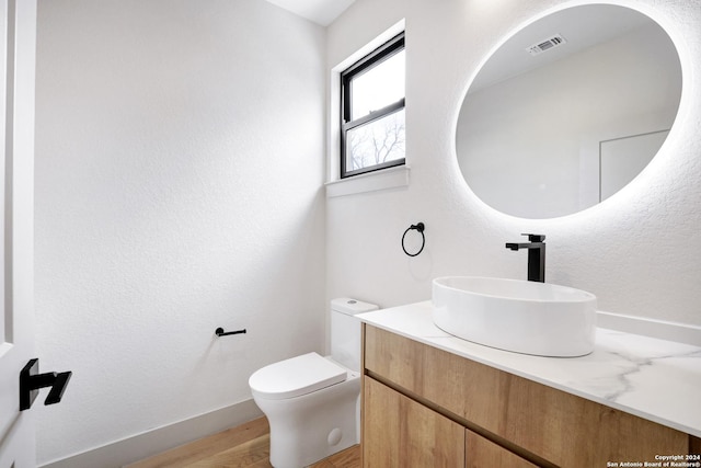 218 Pinckney St, San Antonio, TX 78209 - half bath featuring vanity, visible vents, toilet, wood finished floors, and baseboards