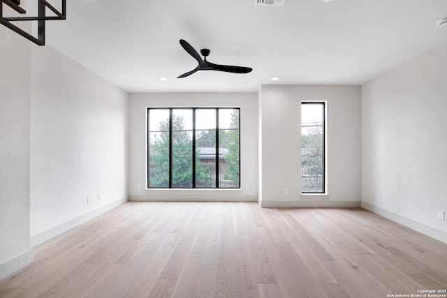 unfurnished room featuring ceiling fan, plenty of natural light, and light wood-type flooring