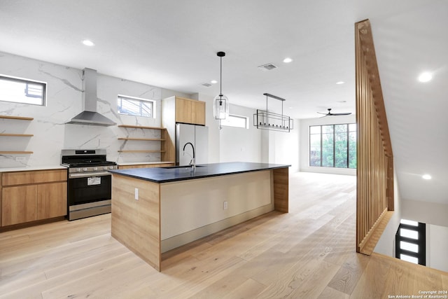 218 Pinckney St, San Antonio, TX 78209 - kitchen with wall chimney range hood, freestanding refrigerator, gas range, visible vents, and modern cabinets