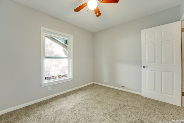 empty room featuring light carpet, ceiling fan, and plenty of natural light