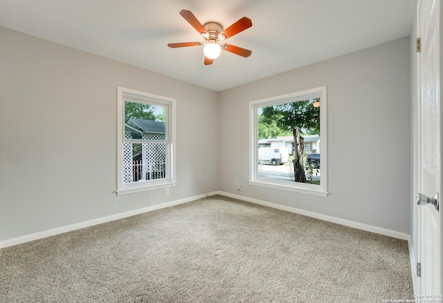 empty room featuring carpet, a healthy amount of sunlight, and ceiling fan