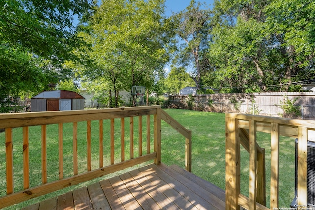 wooden terrace featuring a storage unit and a lawn