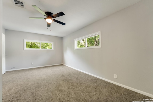 carpeted spare room with ceiling fan