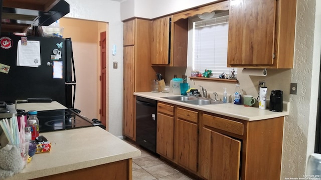 kitchen featuring black appliances, brown cabinets, a sink, and light countertops