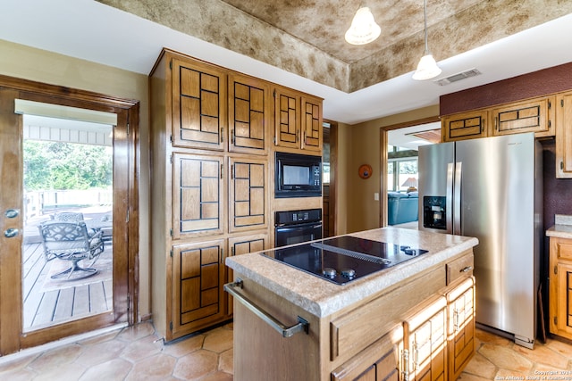 kitchen featuring black appliances, pendant lighting, a center island, and a wealth of natural light