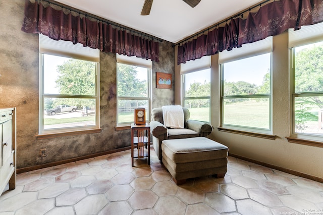 living area featuring light tile patterned floors and ceiling fan