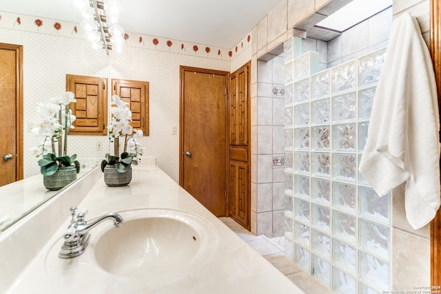 bathroom with dual bowl vanity and tile walls