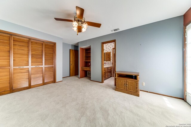 bedroom featuring ceiling fan, light carpet, and a closet