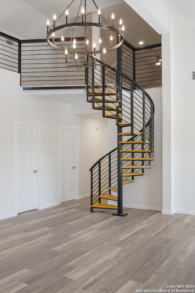 stairway with a towering ceiling and hardwood / wood-style floors