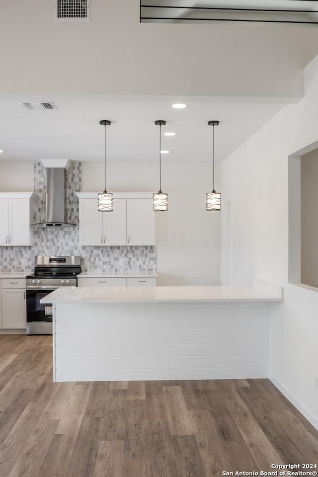 kitchen featuring white cabinetry, stainless steel range with electric stovetop, wall chimney exhaust hood, and pendant lighting