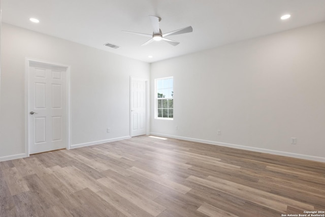 empty room with ceiling fan and light wood-type flooring