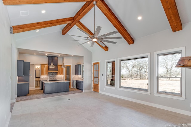 unfurnished living room with ceiling fan, high vaulted ceiling, and beam ceiling