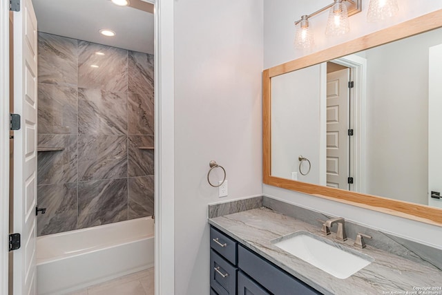 bathroom with tiled shower / bath and vanity