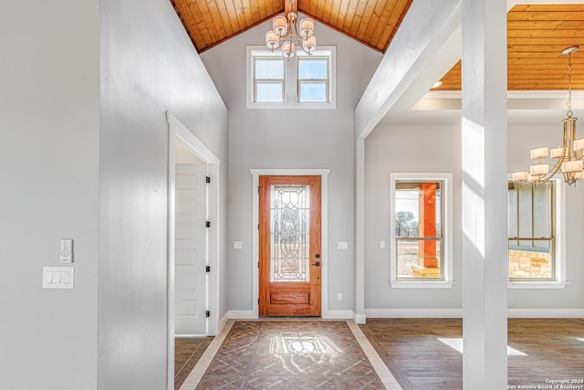 entrance foyer with a notable chandelier, wood ceiling, high vaulted ceiling, and a healthy amount of sunlight