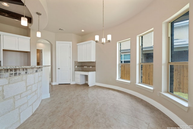 unfurnished living room with light tile patterned floors and a chandelier