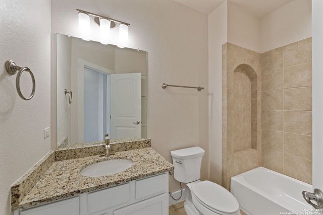 full bathroom with vanity, tiled shower / bath, and toilet