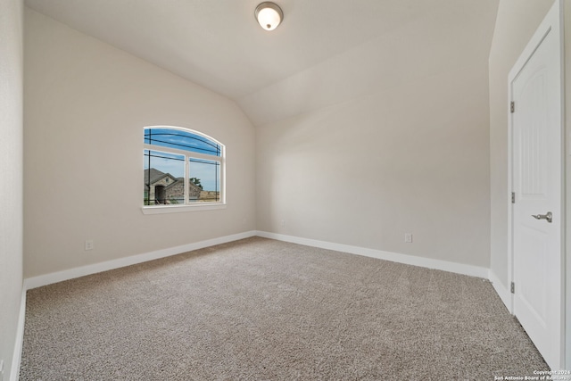 carpeted spare room featuring lofted ceiling