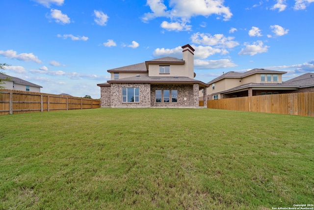 rear view of property featuring a yard